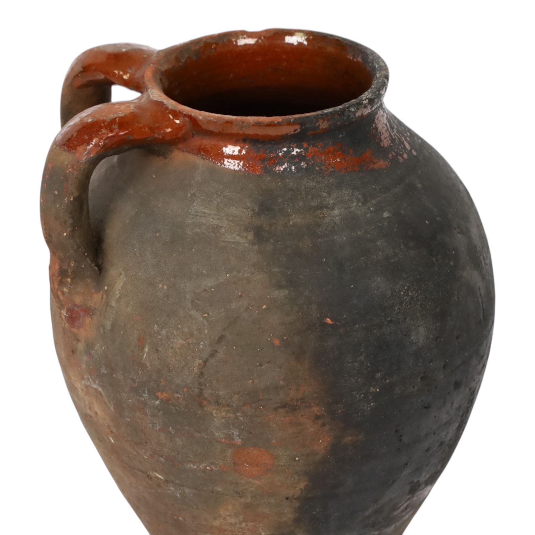 Three early 20th century Spanish part glazed terracotta storage vessels, the first example of bellied form with rounded base and twin loop handles, H24cm, the second of baluster for with close set loop handles, H30cm, and the third smaller also of baluster form with single loop handle, H24cm