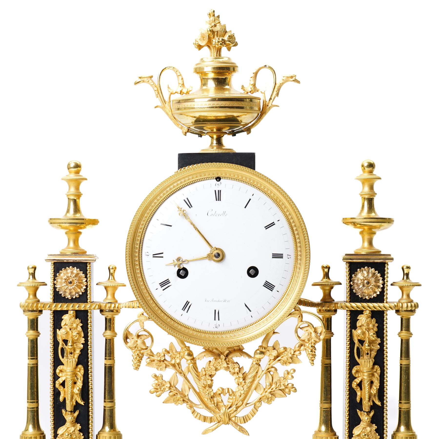French-Early 19th century 8-day ormolu and polished black slate portico clock, case surmounted with a twin handled urn with flowers, supported by two square pedestals with finials and trailing floral mounts on oval bases, raised on an oval plinth with toupie feet, enamel dial signed 