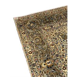 Persian Meshed carpet, ivory ground and decorated with intricate floral design with trailing scrolled branch, the central medallion decorated with stylised plant motifs, seven band border, the main band decorated with scrolls and flower head motifs