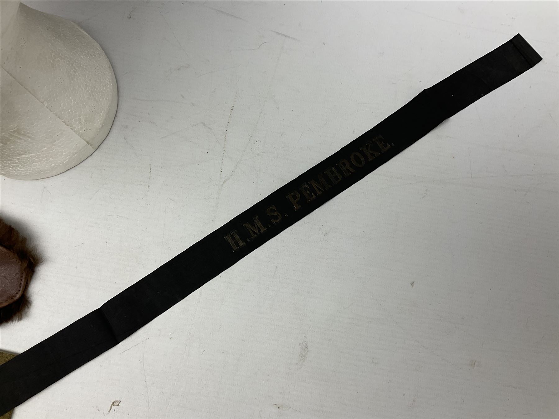 WW1 British Army Derby Scheme 1915 Attested armband; beret with East Yorkshire cap badge; pair of fur lined leather flying/motorcycle goggles; HMS Pembroke cap band; and small quantity of RNAS cloth and metal badges etc