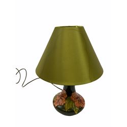 Moorcroft table lamp decorated in the hibiscus pattern on a green ground, with impressed mark beneath H25cm with impressed mark beneath together with a green lampshade.  