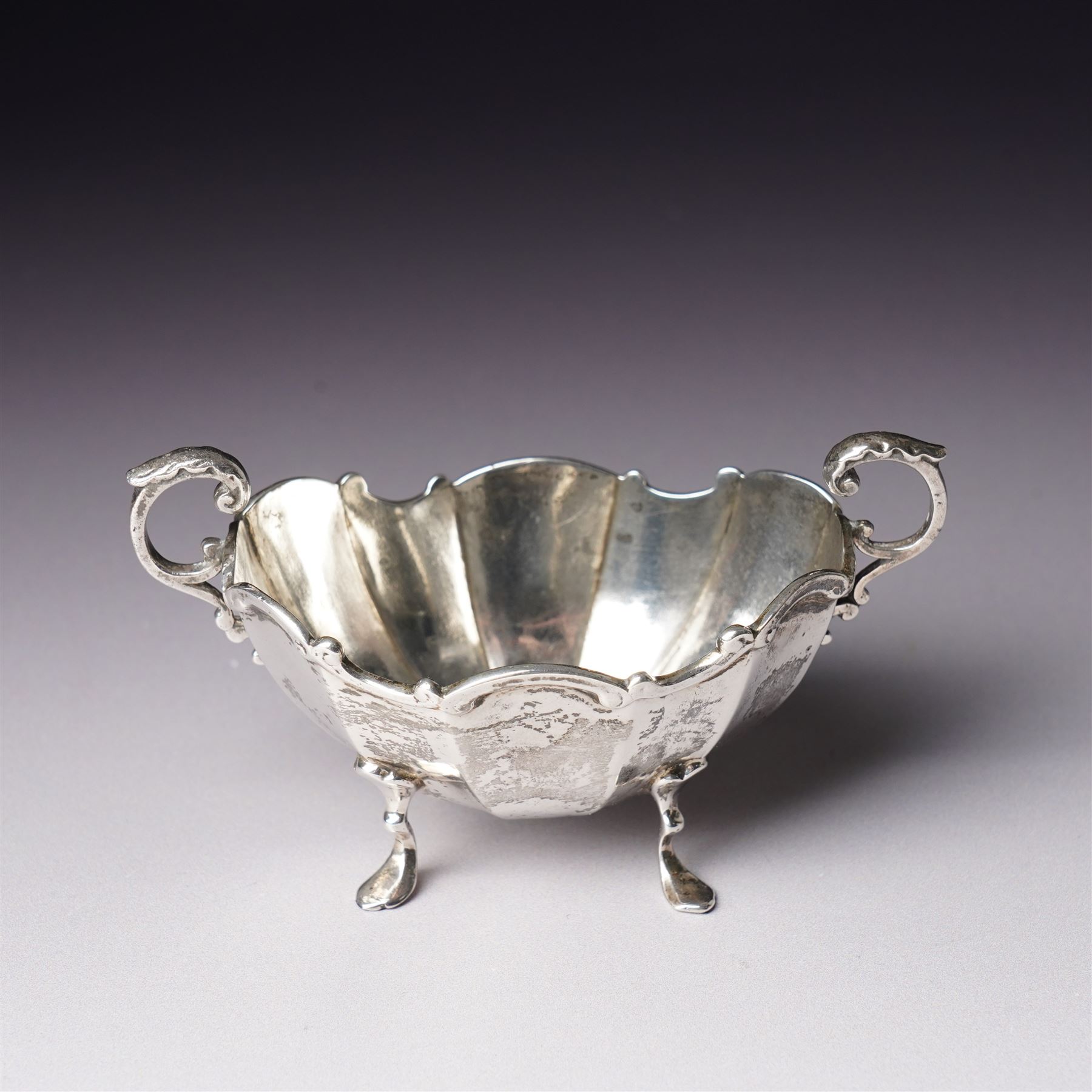 Pair of late Victorian silver salts of oval panel sided design with scroll handles and shaped supports Birmingham 1899 Maker Henry Matthews and two later silver salt spoons 