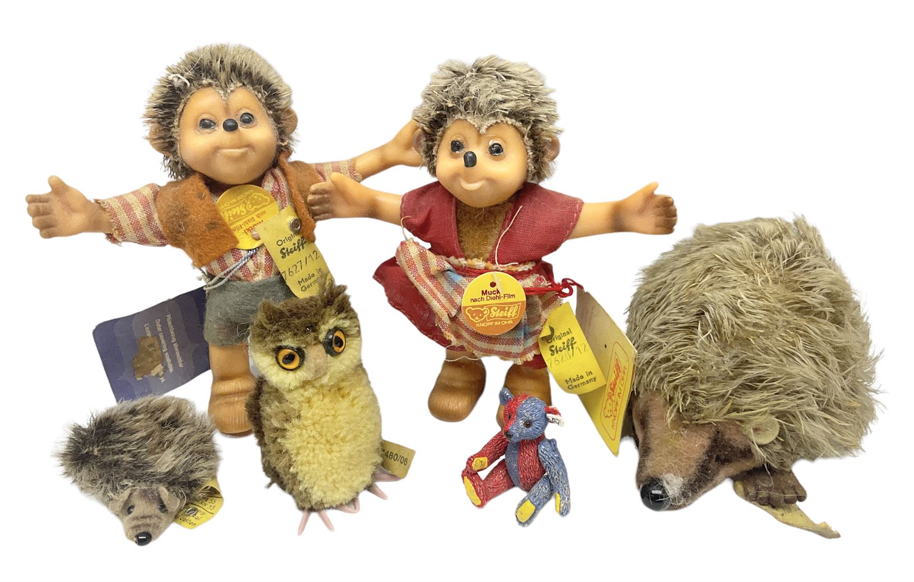 Group of Steiff figures, comprising Mikki and Mukki, circa 1950s no 7628/12 and 7627/12, with original tags, two hedgehogs no 1570/10, and another smaller 1670/03, small owl no 7480/06, and painted metal Steiff harlequin style bear