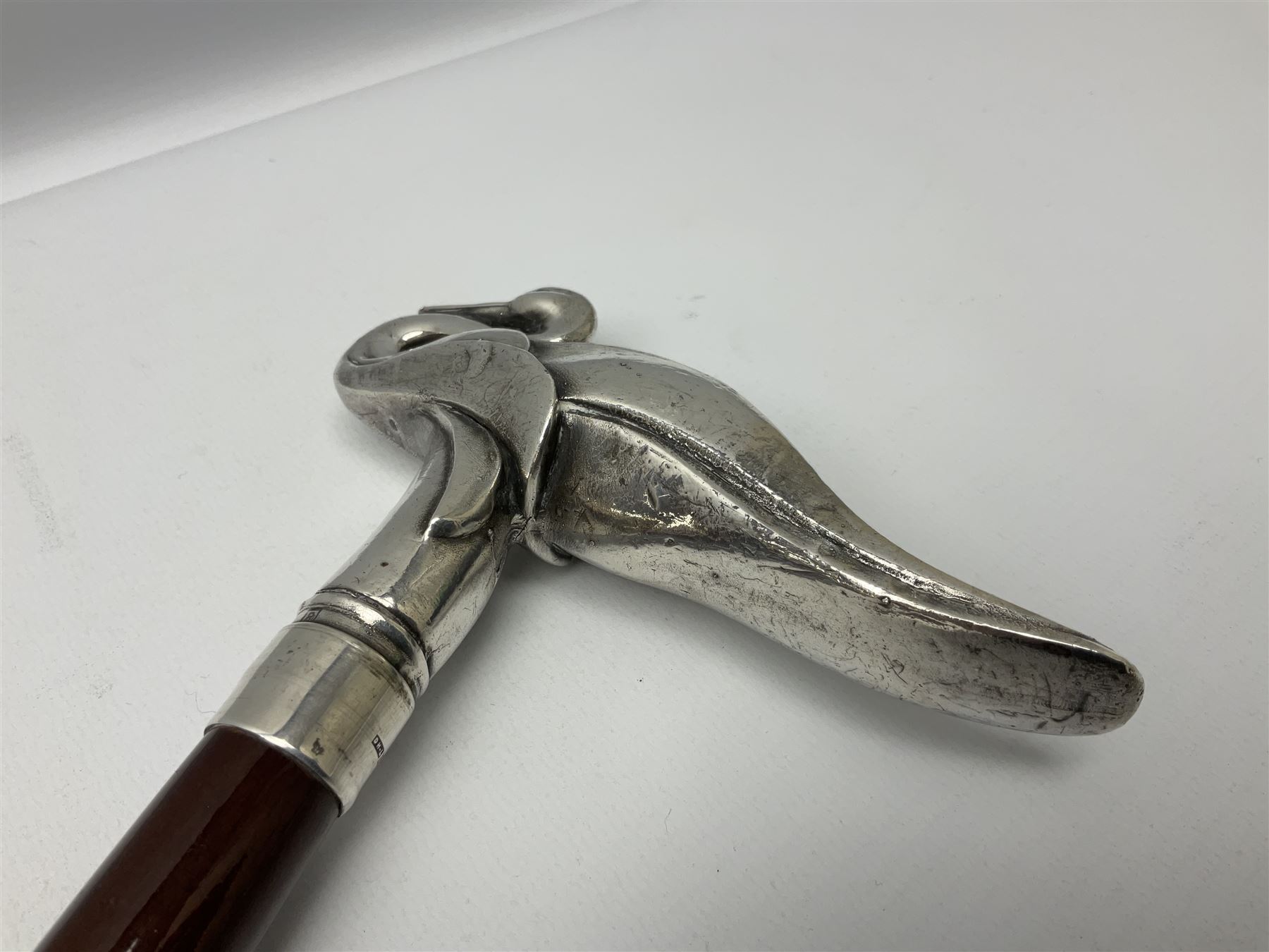 Art Deco style Italian 'Rivestito' covered silver walking stick handle, modelled in the form of a swan, stamped 'R', upon a silver collar hallmarked Birmingham 1986, makers mark DH-L, and hardwood shaft, L96cm

Provenance by vendor repute: 
This walking cane comes from a private collection amassed by the current vendors mother who was an Antique dealer specialising in walking sticks, working at the Portobello Road Antique Market in London for over forty years. 
In 1988 the prop crew from LWT (now ITV) visited Portobello Road looking for, amongst other items, a signature stick for David Suchet to use in his portrayal of Agatha Christie's Poirot. 
At the time this particular walking stick was one of five in possession. The prop crew chose and purchased another of the five which was then used by Suchet throughout all seventy episodes of the much loved series. 
Following the conclusion of the series Suchet was gifted his particular cane, which has been loaned to and can now be seen at the Agatha Christie Gallery at the Torquay Museum. 
