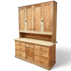 Early 20th century pine and beech kitchen dresser, projecting cornice above three panelled cupboard doors, base fitted with three drawers and twin panelled cupboards, on plinth base