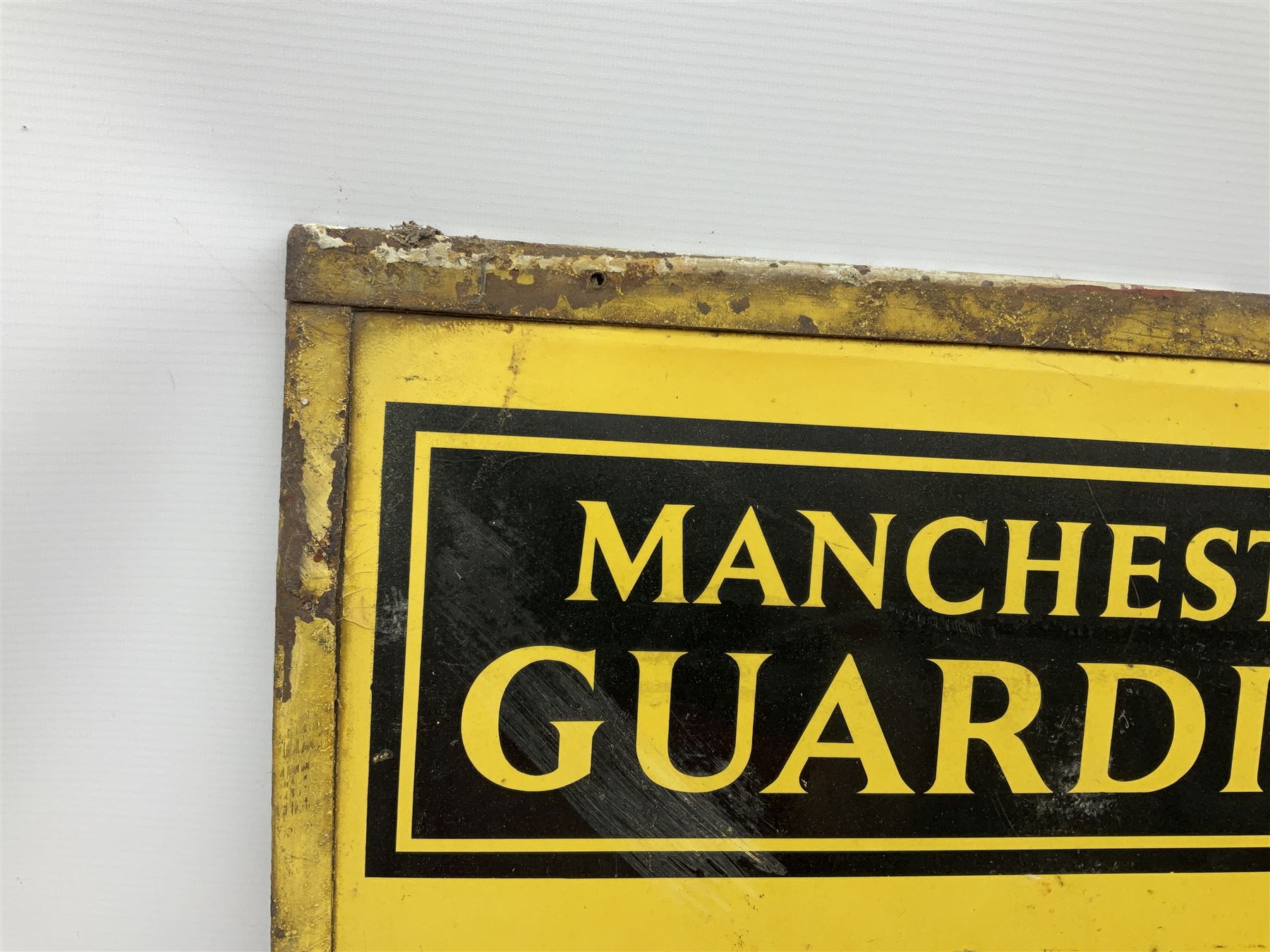 Enamel street advertising sign for The Manchester Guardian, with black lettering on yellow ground, H79cm W52cm