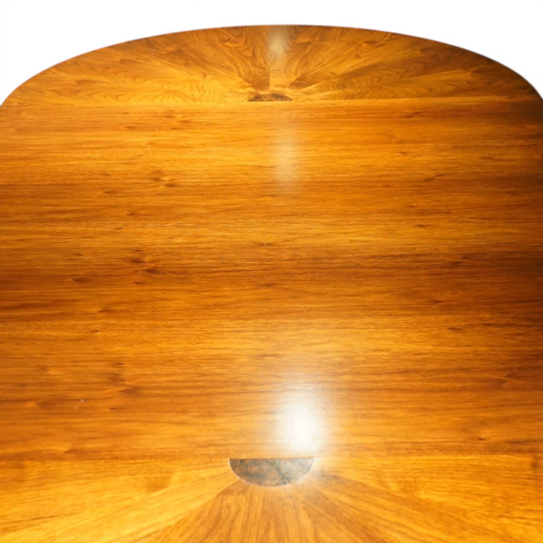 Late 20th century Regency design walnut twin pedestal dining table, the oval top with radial sunburst veneered ends centred by roundels, upon twin pedestal turned column supports, issuing to down swept triform bases