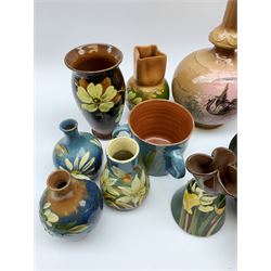 Collection of Devon pottery all having floral slip decoration and include Aller Vale, Watcombe, possibly some Longpark, and other unmarked pieces, tallest H25cm together with a pair of T. Forester jugs hand-painted with cranes and two further Devon pottery pieces, both hand-plated with birds 