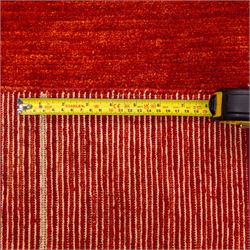 Two contemporary Moroccan Berber hand-woven rugs, deep madder red field of plain design, 199x153cm, other with deep madder red field with a simple lattice of ivory lines forming panels with some tonal variation, 190x146cm 