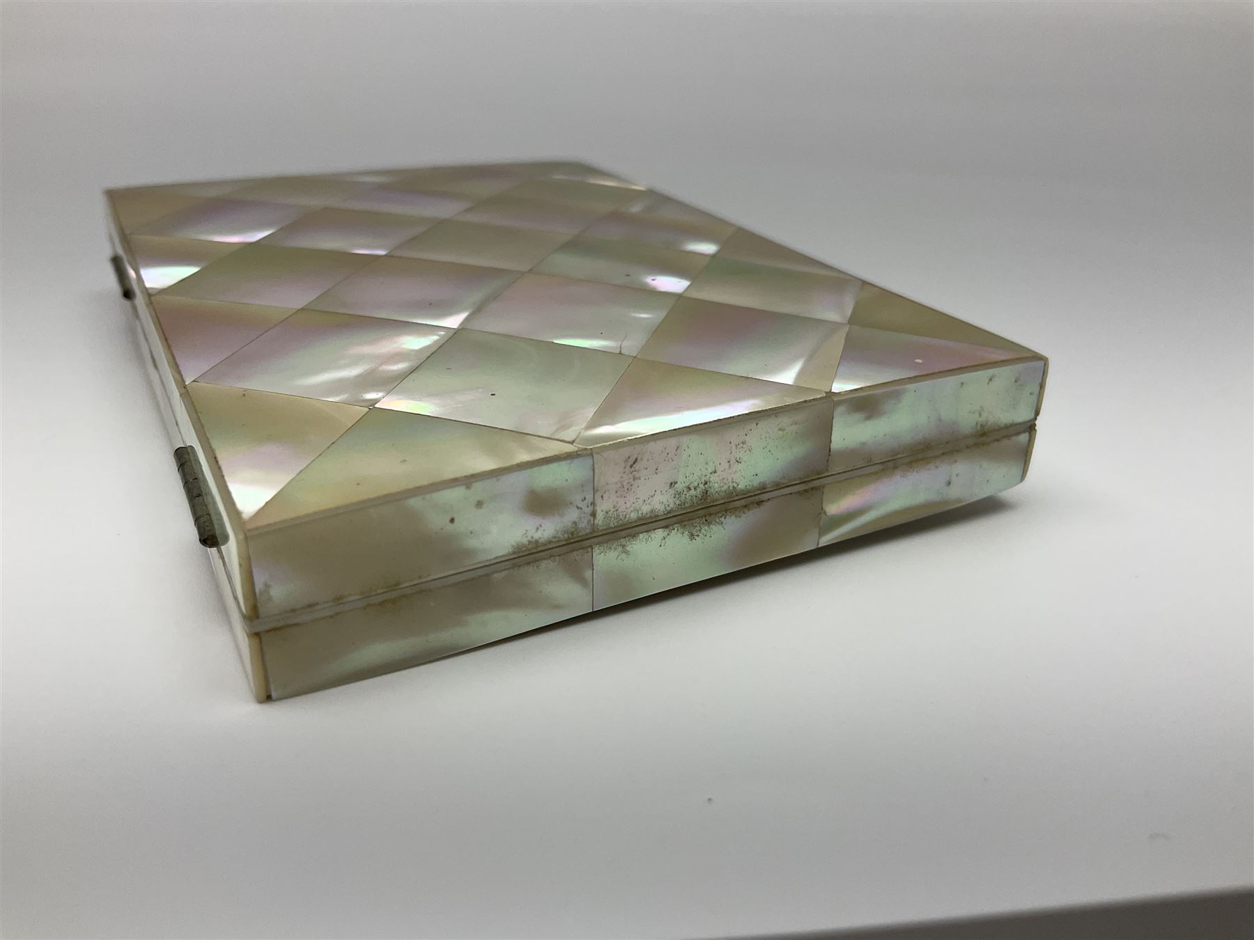 Victorian mother of pearl tea caddy, of rectangular bow-fronted form, the body with floral, bird and geometric engraved mother of pearl panels, white metal shield plaque to the cover inscribed with the initials G.J.A and similar escutcheon, the two division interior with ivory edging and two panelled mother of pearl lids, on four vegetable ivory bun feet L20cm, together with a similar style mother of pearl card case (2) This item has been registered for sale under Section 10 of the APHA Ivory Act