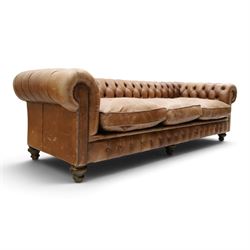 Fleming & Howland Ltd - large traditional shape four seater chesterfield club sofa, the rolled ack and arms with studwork, upholstered in buttoned tan leather with loose seat cushions, raised on large turned feet