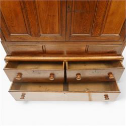 18th century oak larder cupboard, projecting moulded cornice over two panelled doors with shaped arched fielded panels, three short dummy drawers above base fitted with two short and one long drawer, turned handles, on bracket feet
