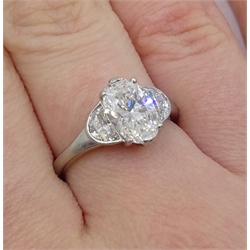  Platinum three stone diamond ring, the oval centre stone of approx 1.80 carat with two half moon cut diamonds either side, each weighing approx 0.50 carat, hallmarked, total carat weight approx 2.80 carat  