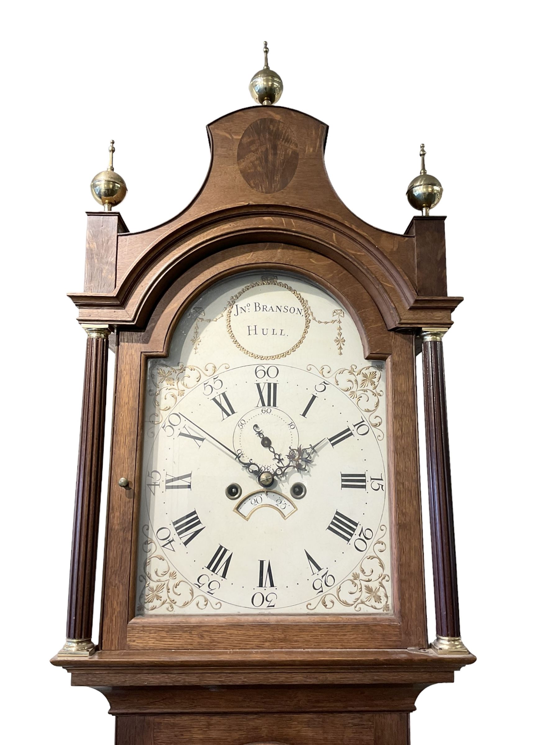 John Sculcoates Branson of Hull - Oak cased 8-day longcase clock c1790, with an inlaid perogda pediment and three ball and spire finials, breakarch hood door beneath flanked by reeded pilasters and brass capitals, long trunk with conforming door on a rectangular plinth raised on a base with bracket feet, early painted dial with raised gesso spandrels, swag cartouche and makers name to the arch, with pierced steel hands, Roman numerals,five minute arabics, seconds dial and calendar aperture, dial pinned via a false plate to a rack striking movement with a recoil anchor escapement. With weights, pendulum and key.