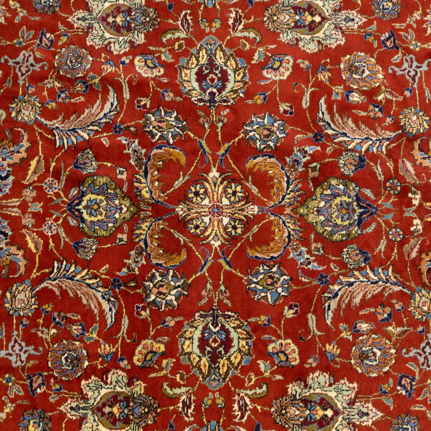 Persian Tabriz hand-knotted carpet, crimson field densely decorated with scrolling floral and foliate motifs, enclosed by a broad cream principal border with repeating floral medallions and multiple guard stripes