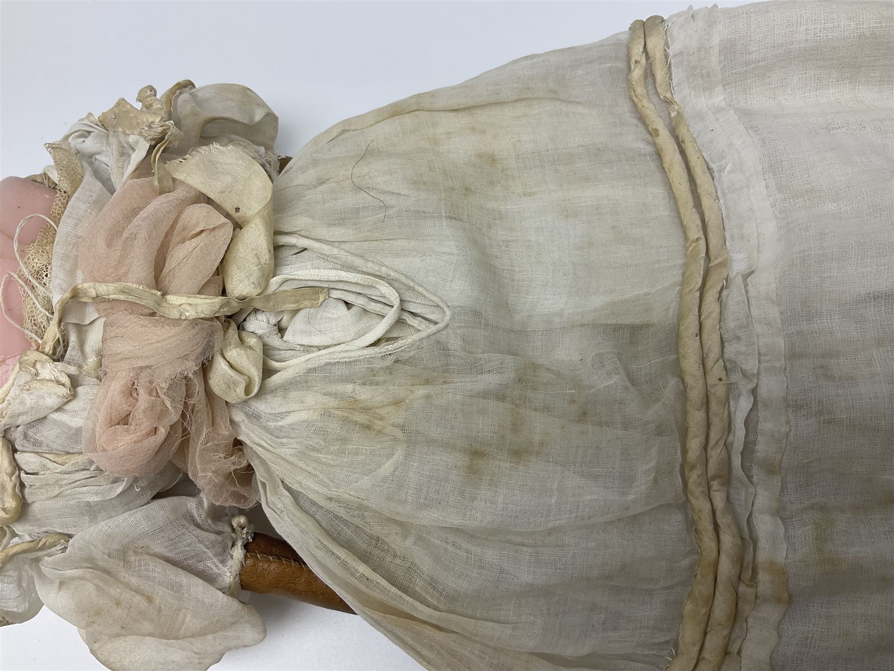 Victorian wax shoulder head doll with pale complexion, applied hair, inset glass eyes and fabric covered jointed body with kid leather lower arms; white linen dress and undergarments H50cm