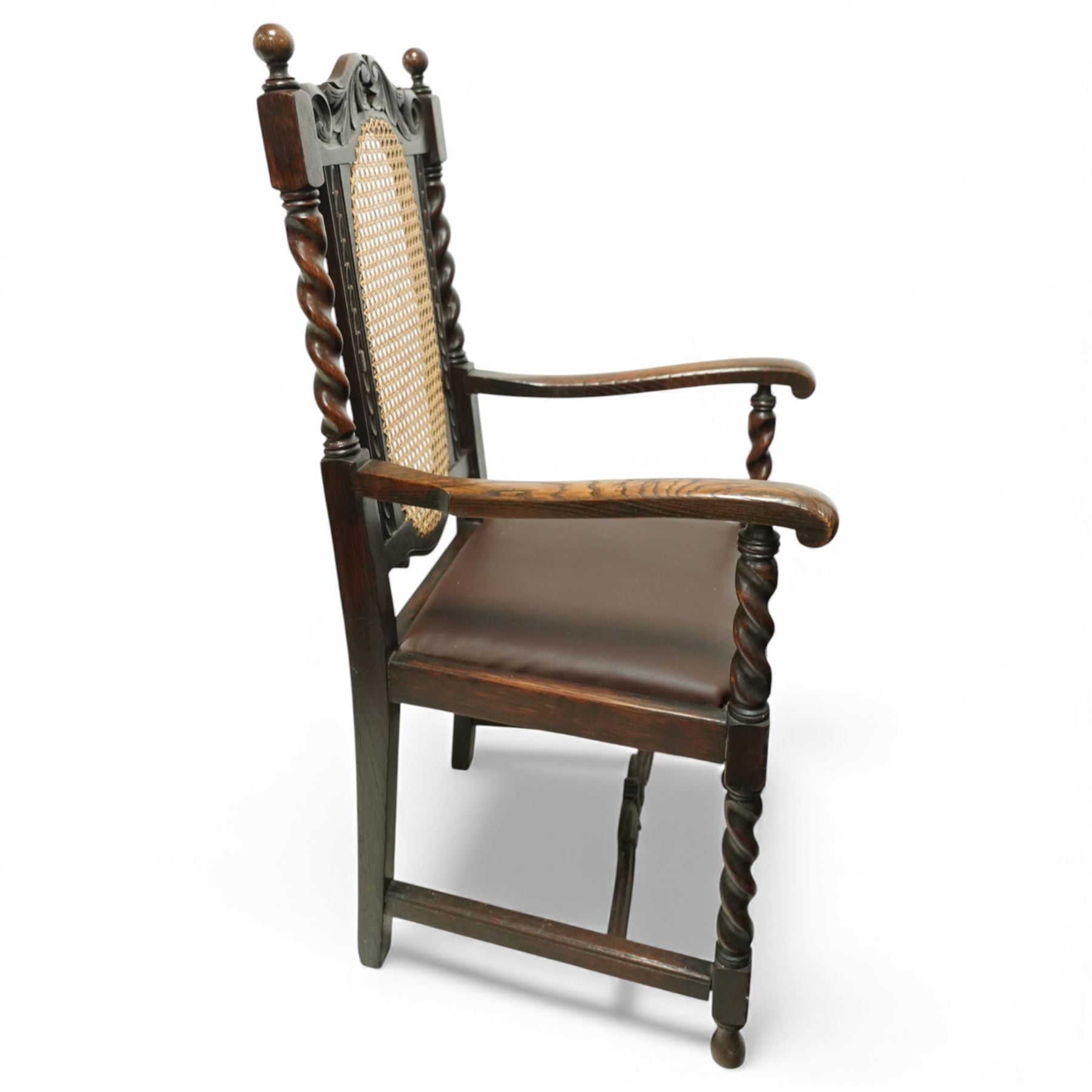 Victorian Jacobean revival oak carver chair, carved scroll cresting rail over an oval back panel later caned, open arms on barley-twist supports, padded seat, raised on spiral turned legs united by a shaped front stretcher
