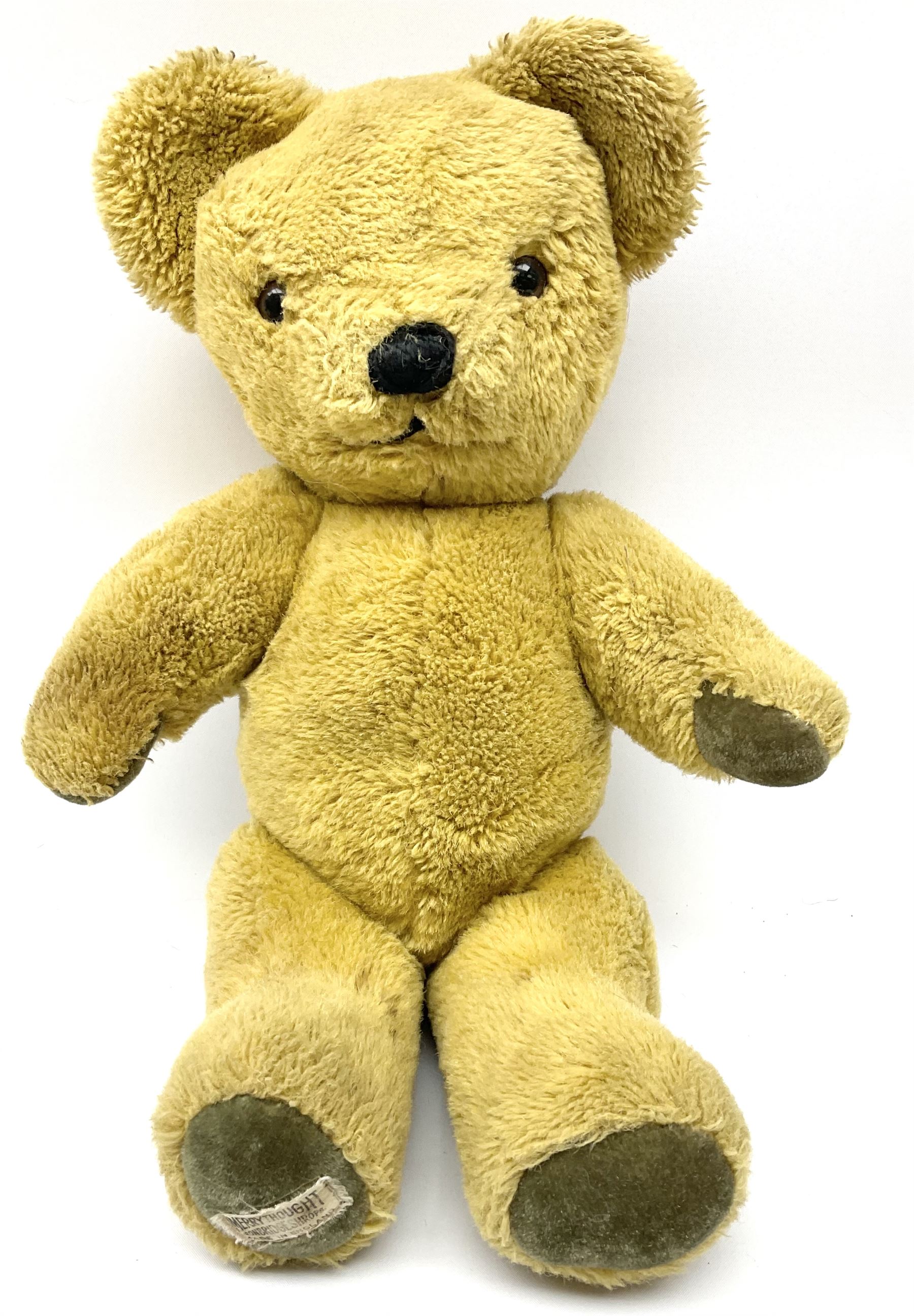 Four Merrythought teddy bears - International Collectors Club limited edition with growler mechanism No.71; plain brown with back-wind musical movement; golden brown dressed as a Beefeater; and earlier light golden coloured (4)