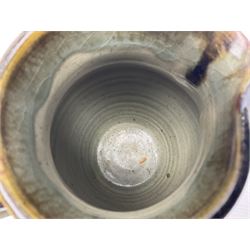 Michael Leach (British 1913-1985) for Yelland pottery; two large glazed stoneware plates with dark brown stylised decoration upon oatmeal ground, together with a jug in merging blue, green and brown, all with impressed marks beneath, largest plate D37cm