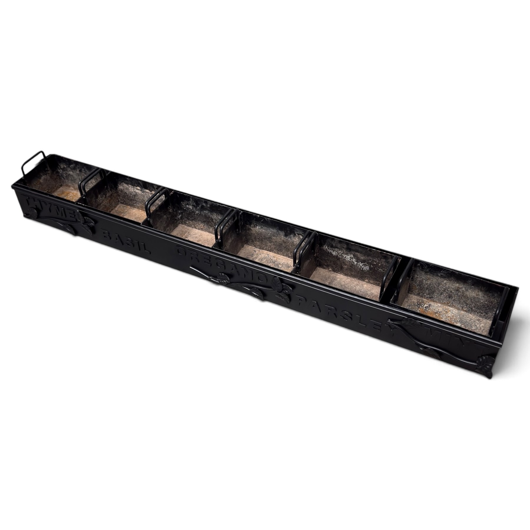 Black-painted iron herb planter, the long rectangular body embossed ‘Thyme, Basil, Oregano, Parsley, Mint’ with applied foliate decoration, containing five removable handled liners