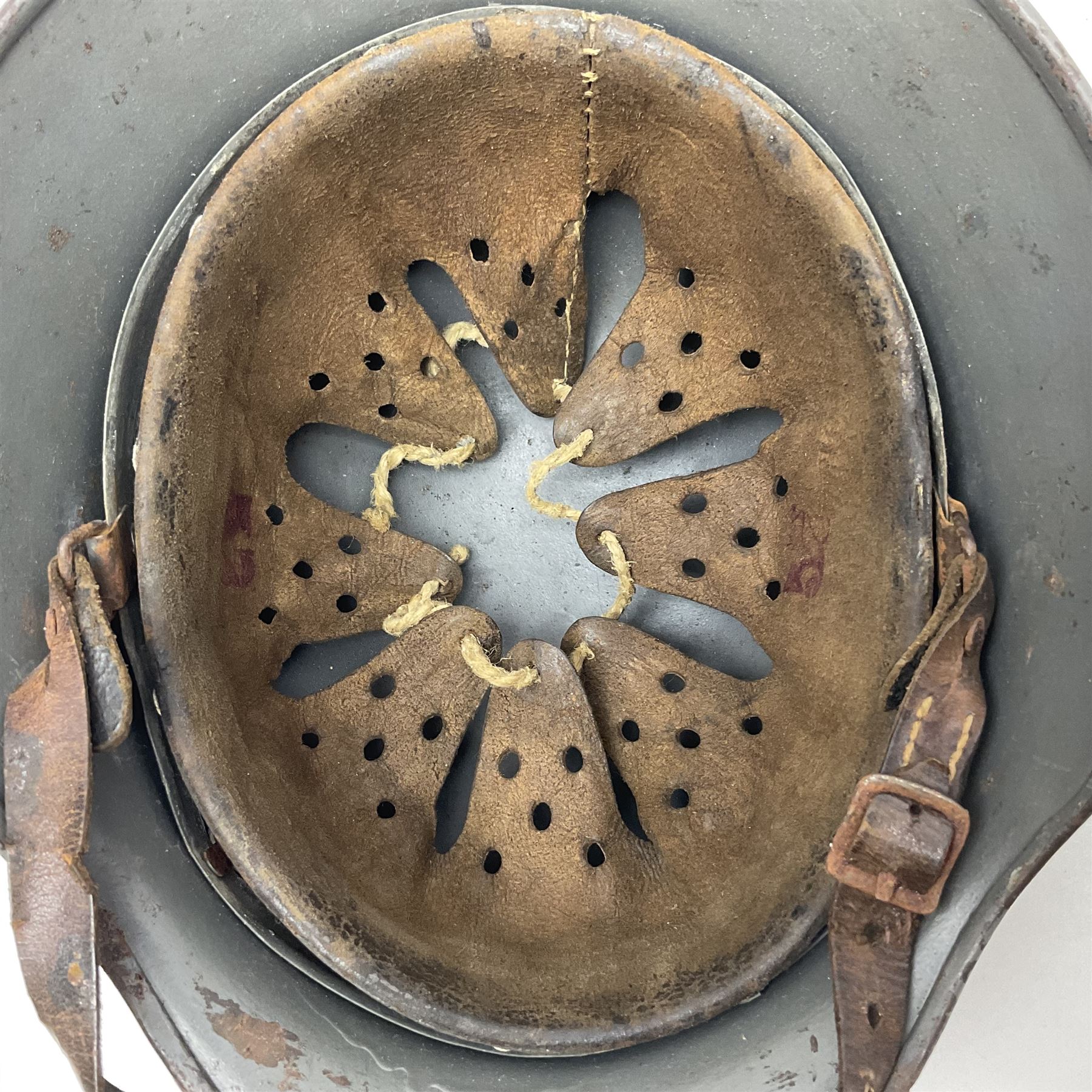 WW2 German Infantry M40 steel helmet with tropical finish and traces of single decal; with chin strap and leather liner marked 57 twice in red; back apron stamped 11 38