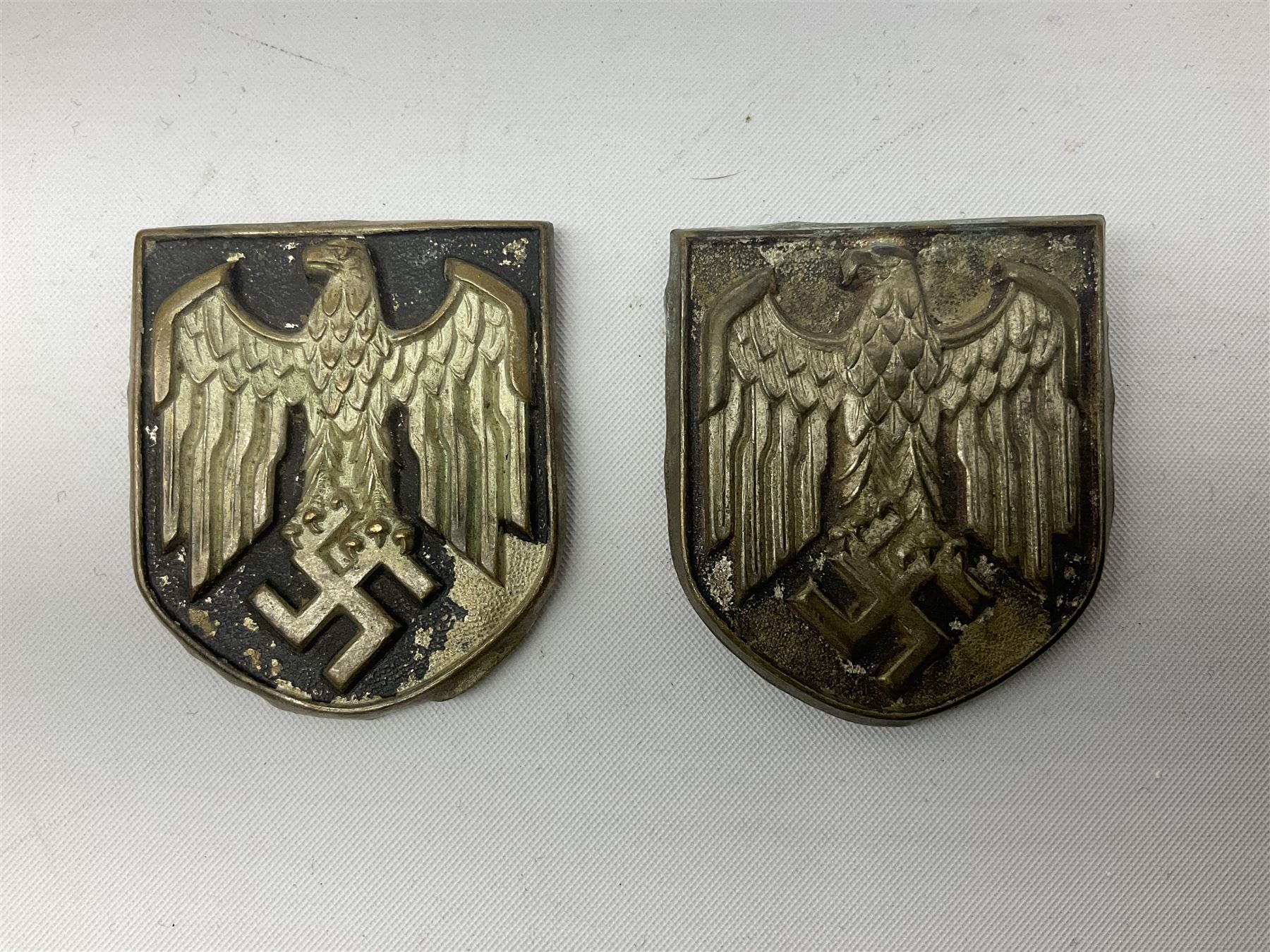 Two WW2 German Army Afrika Korps pith helmet metal side badges; RAD oval metal badge by J.B.u.Co.; WW1 German 1914-1915 bar brooch; and Nienburg War Veteren's Association badge (5)