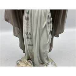 Lladro figure, The Loaves and Fishes, modelled as Jesus Christ with arms raised standing beside a basket of loaves and a basket of fish, sculpted by Salvador Furió, with original box, no 5896, year issued 1992, year retired 1997, H35cm