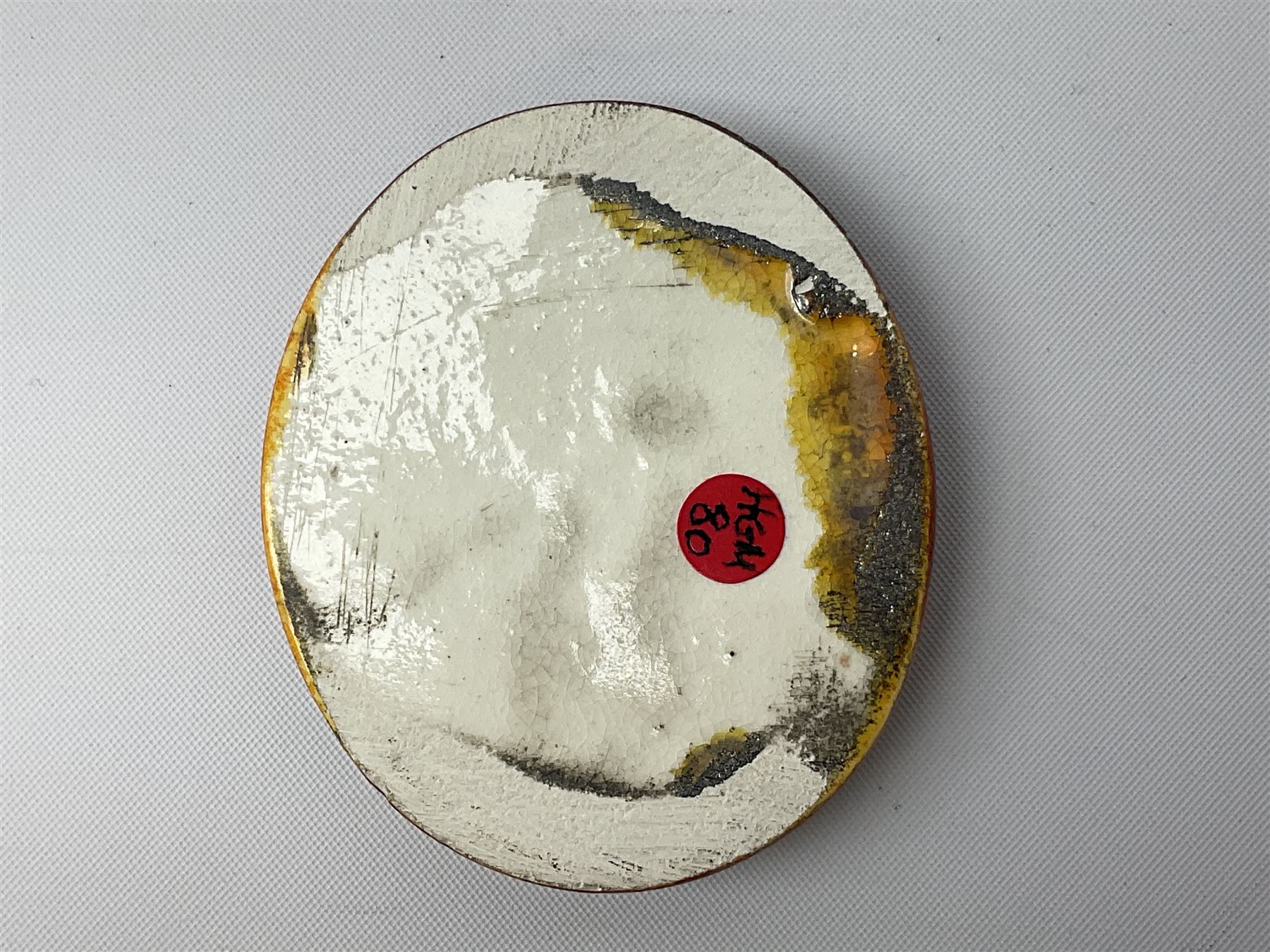 Henry George Murphy (1884-1939), collection of seven Arts & Crafts glazed ceramic roundels, of circular and oval form, five in tones of red and brown and two in tones of blue, turquoise and green in soufflé and high fired finishes, largest example D6.5cm