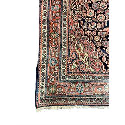 Persian indigo ground rug, the field decorated with intricate interlaced foliage branches and small flower heads, shaped floral design central medallion, the border decorated with scrolling branch and flower heads within guard bands 