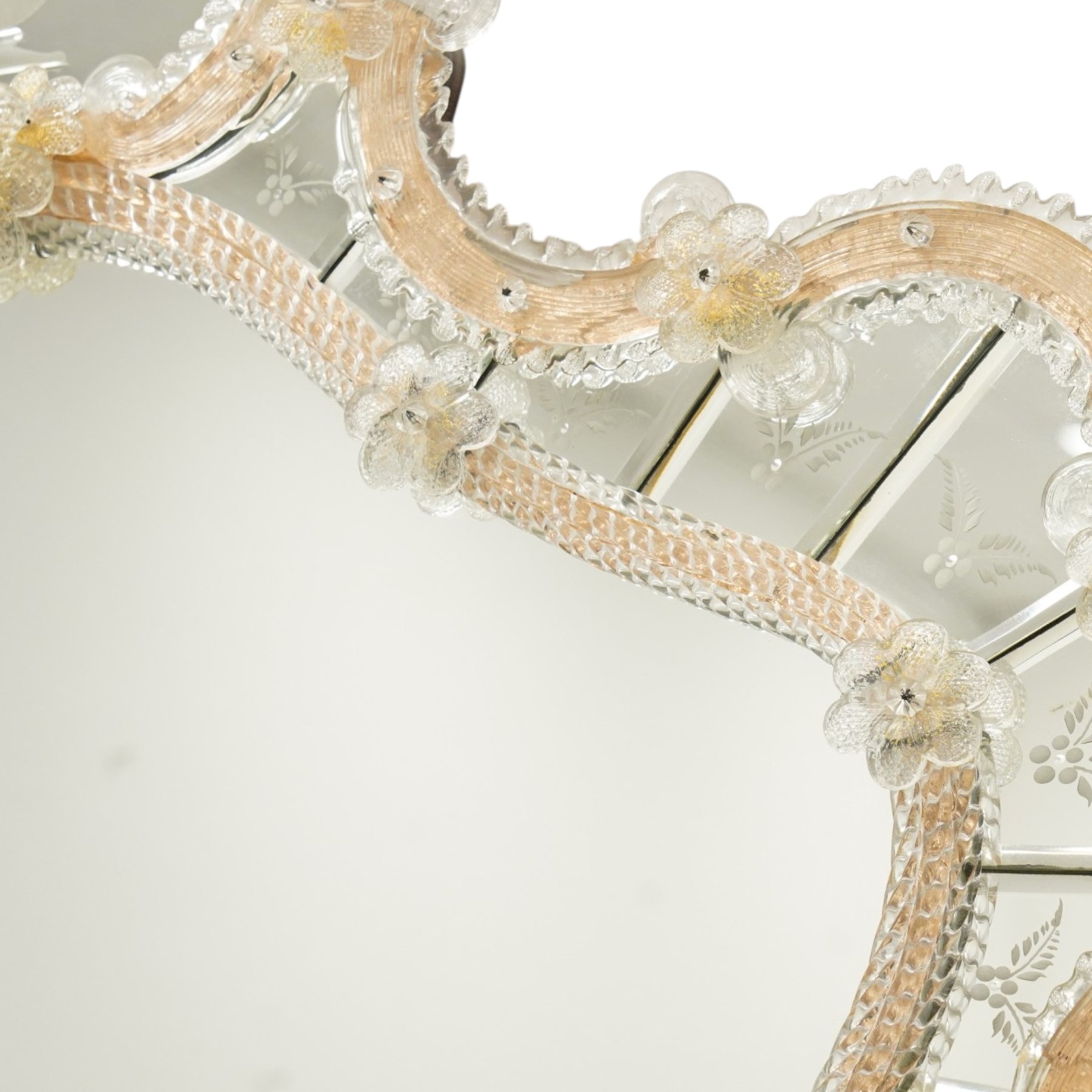 20th century Venetian glass wall mirror, the shaped plate within a mirrored frame applied with clear glass flowerheads and moulded glass edging, with etched floral decoration to the bevelled 'frameless' plates, the inner slip with ropetwist moulded glass