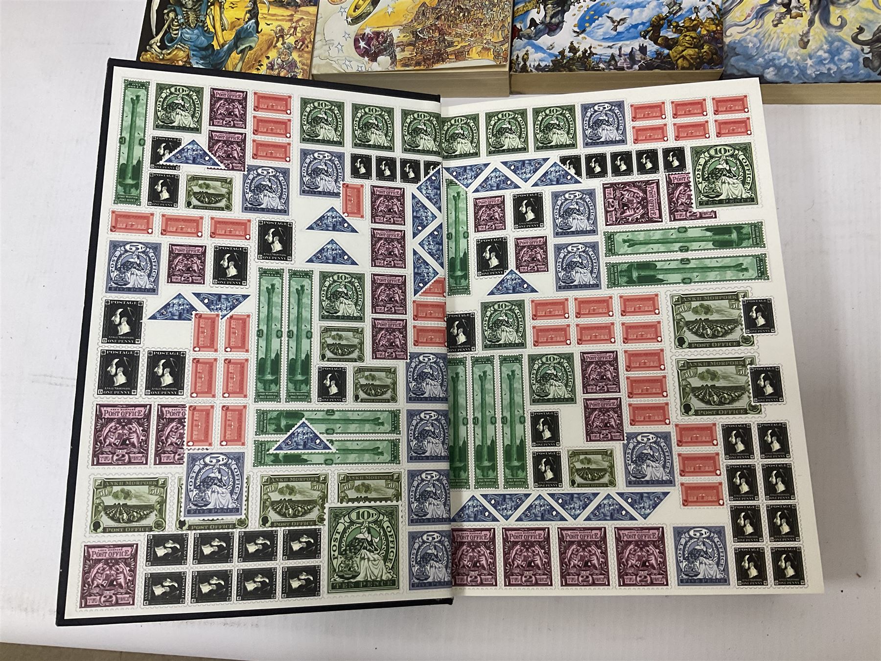 Collection of books by Terry Pratchett, of mostly Discworld interest, to include hardback edition of Going Postal, and further books such as Men at Arms, Sourcery, Small Gods etc 