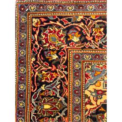 Central Persian Kashan crimson ground rug, central indigo pole medallion surrounded by sparsely placed bouquets interconnected with foliate branches, the guarded border with repeating palmette and Boteh motifs with interwoven scrolling patterns, framed by guard stripes