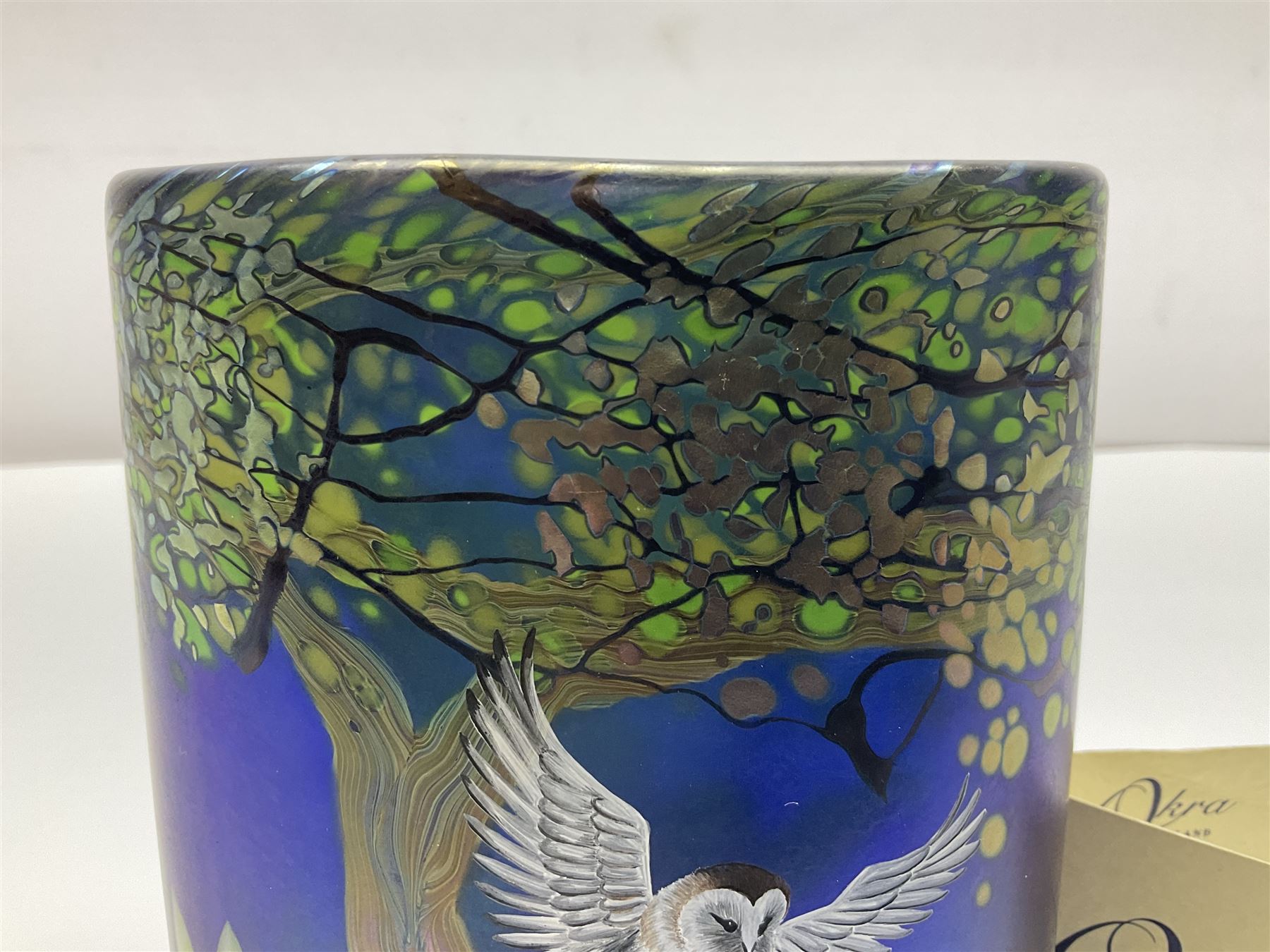 Okra limited edition glass vase, Night Owl, no 19/50, designed by Terri-Louise Colledge, of oval form, painted with a barn owl taking flight amongst leafy branches, upon an iridescent blue ground, etched marks and dated 2002 beneath, with limited edition certificate, H16.8cm, unboxed 