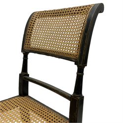 Collection of Regency dining chairs - set of four Regency painted beech dining chairs, with cane seat and back, on collar turned supports with splayed feet (W46cm, H84cm); a pair of Regency ebonised dining chairs (W47cm, H77cm); and a single Regency dining chair, the cresting rail painted with floral cornucopias and central putto vignette, X-frame back over cane seat, on collar turned front supports painted with foliage (W46cm, H84cm) (7)