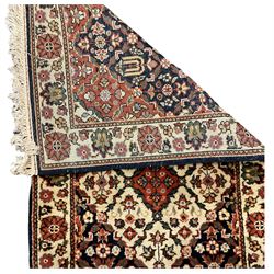 Persian design indigo ground runner, the field decorated with three floral lozenge medallions, decorated all over with small flower heads, repeating border