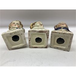 19th century pair of hand painted ceramic busts of children, together with a third similar example of a putti with a crown of ivy, tallest H23cm 