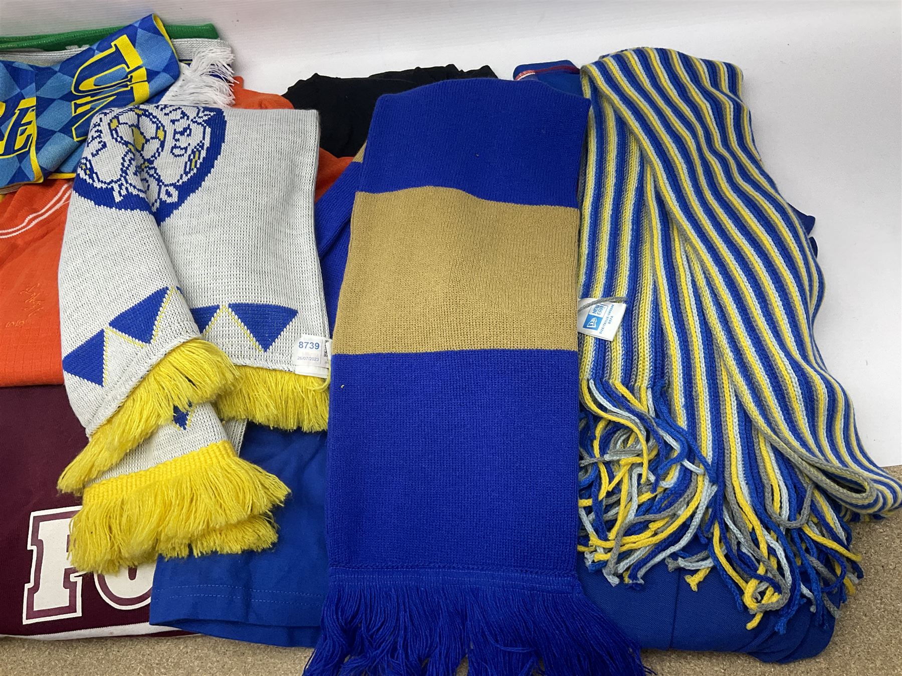 Collection of Leeds United scarves, hats and t-shirts, together with a Washington Redskins NFL sweatshirt and an Australian rugby league shirt