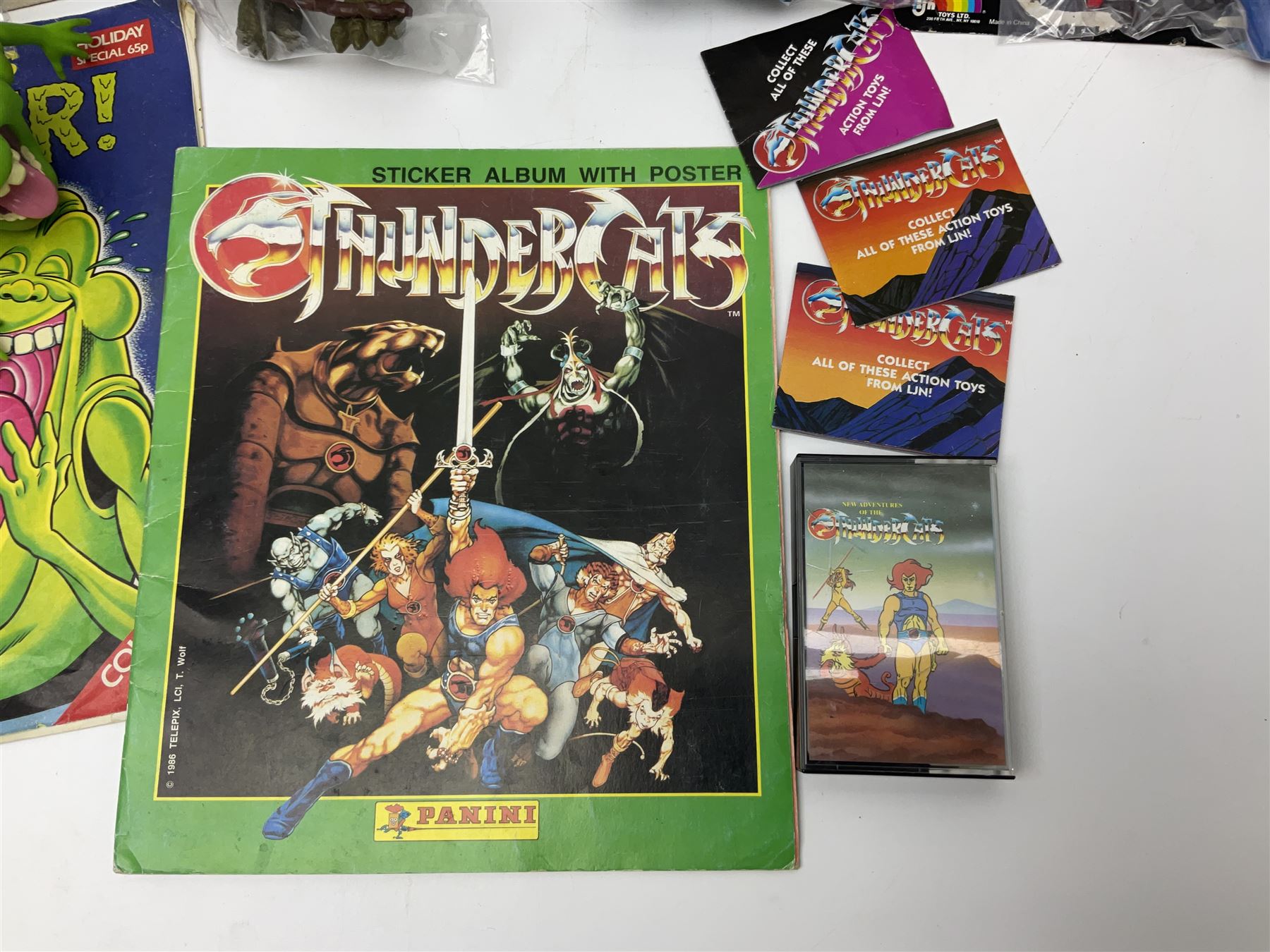 Five 1980s LJN Thundercats figures - Lion-O with sword, Snowman, S-S-Slythe, Tygra and Mumm-Ra; all re-bagged on original backing cards; partially stocked Panini sticker album; story cassette tape and three catalogues; together with Ghostbusters Slimer with food and Comic