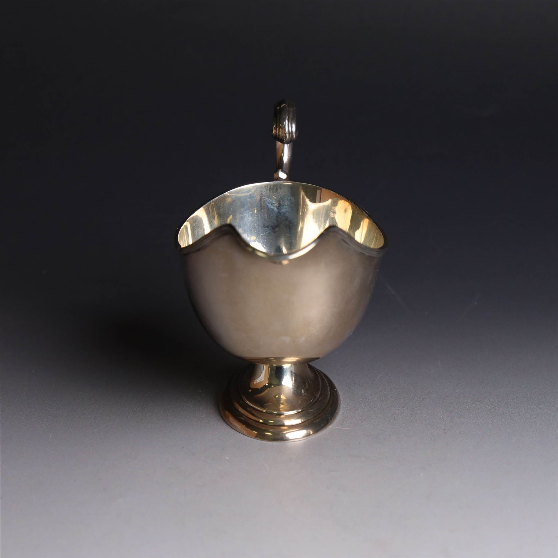 1930s silver sauce boat, of typical form with acanthus capped flying C scroll handle and upon stepped oval foot, hallmarked William Hutton & Sons Ltd, Sheffield 1938, height including handle H10cm