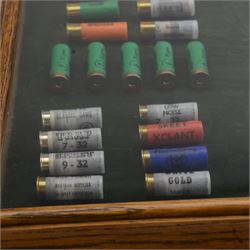 SHOTGUN LICENCE REQUIRED Gamebore shotgun cartridge advertising display board with green background in a glazed oak case, H51cm