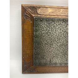 Arts and Crafts oak stand by Arthur Simpson of Kendal, of rectangular form with central hammered pewter panel, surrounded by a border with carved foliate corners, upon two bar supports, bearing label detailed 