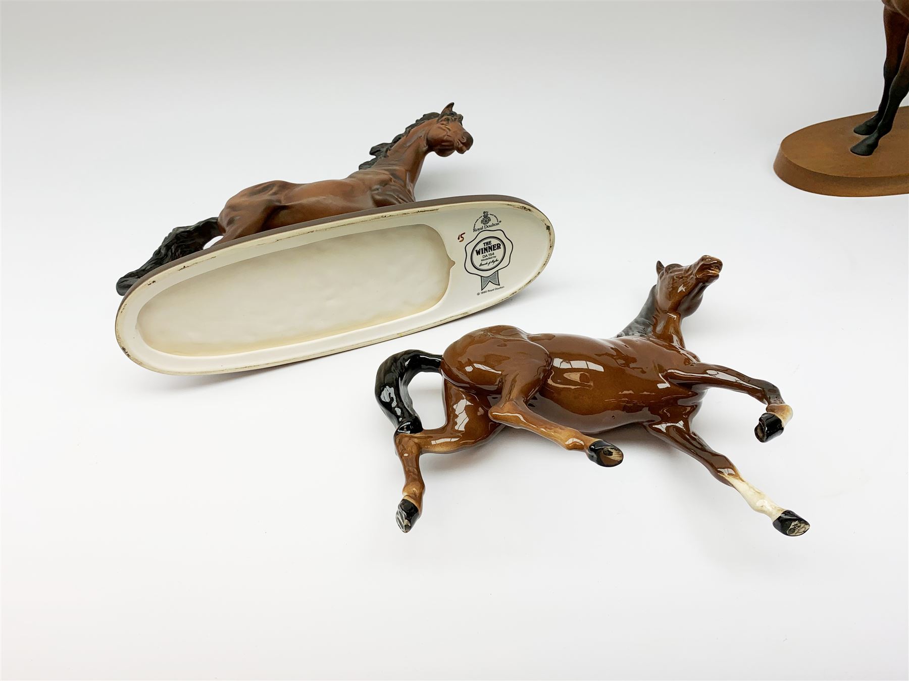 Four Royal Doulton horse figurines, comprising Red Rum, Arkle, and the Winner DA154, and another modelled as a prancing bay horse, largest H32cm. (4). 