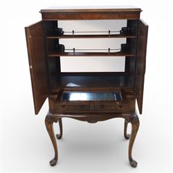 20th century Queen Anne style mahogany cocktail cabinet, moulded cornice above a pair of fielded panel doors with decorative strap hinges and central escutcheon, opening to a mirrored interior fitted with tiered shelves with brass gallery rails, pull-out glass inset mixing slide above three short drawers, shaped apron on cabriole supports with carved shell knees terminating in pad feet