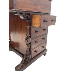 Victorian figured walnut davenport, raised compartment over sloped lid, fitted maple interior, four working drawers to the right hand side, turned front pilasters carved with scroll leaves, on turned feet with castors