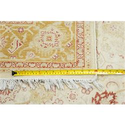Modern Pakistani Oushak style wool hand-knotted carpet,  ivory field with an all-over scrolling floral vine design in soft tones of madder red and pale gold, enclosed by a conforming border, with cotton fringe ends  