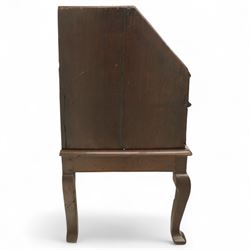 Early 18th century George I oak bureau on original stand, the fall front enclosing an arrangement of correspondence drawers and pigeonholes over central well, fitted with single long drawer below, the shaped apron over cabriole supports with pad feet