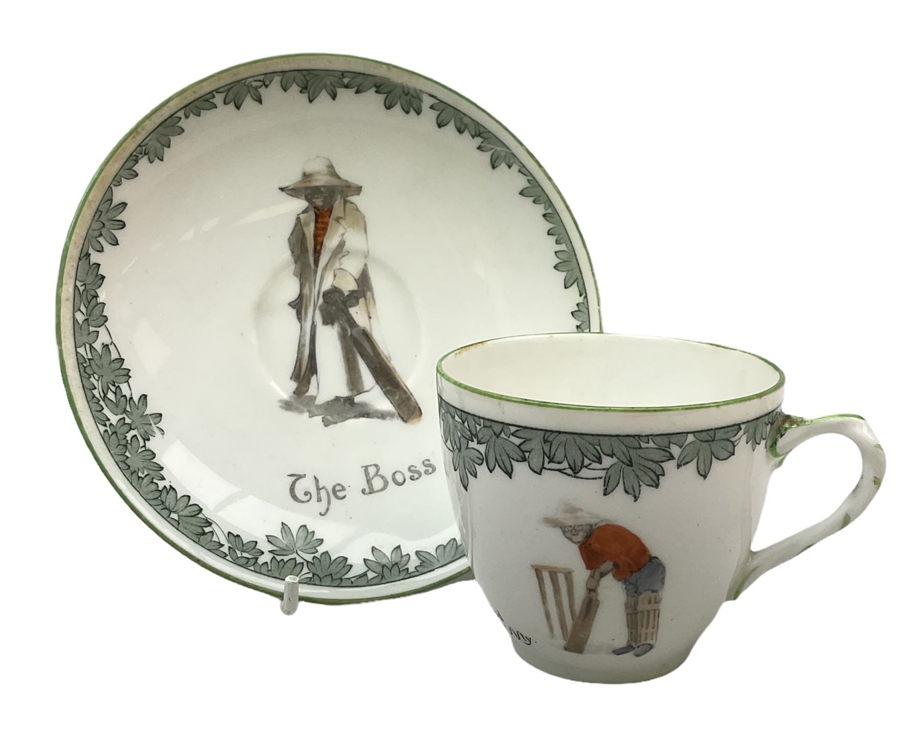Early 20th century Royal Doulton teacup and saucer, from the series 'The All Black Team', the teacup depicting a cricketer entitled 'Good for fifty', the saucer depicting a cricketer stood in a long coat and wide brimmed hat, entitled 'The Boss', both with printed mark beneath, cup H6.5cm