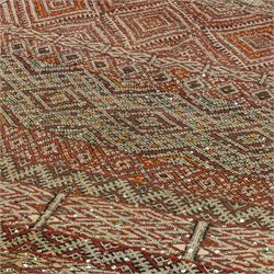 Moroccan Berber kilim rug, flatwoven with bands of geometric lozenge and chevron motifs in red, orange, ivory and green, decorated with applied sequins, fringed ends
