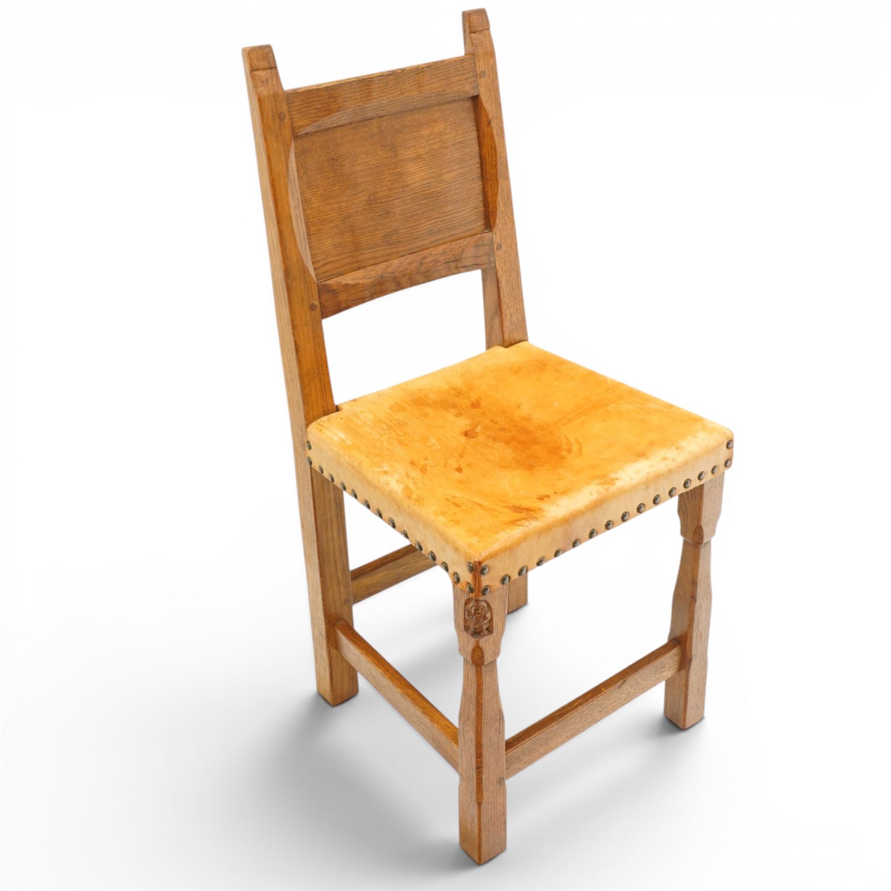 Gnomeman - set of six oak dining chairs, the adzed panelled backs with chamfered rails, over seats upholstered in tan leather, raised on chamfered and tapering square supports united by box stretchers, carved with gnome signature, by Thomas Whittaker, Littlebeck, Whitby