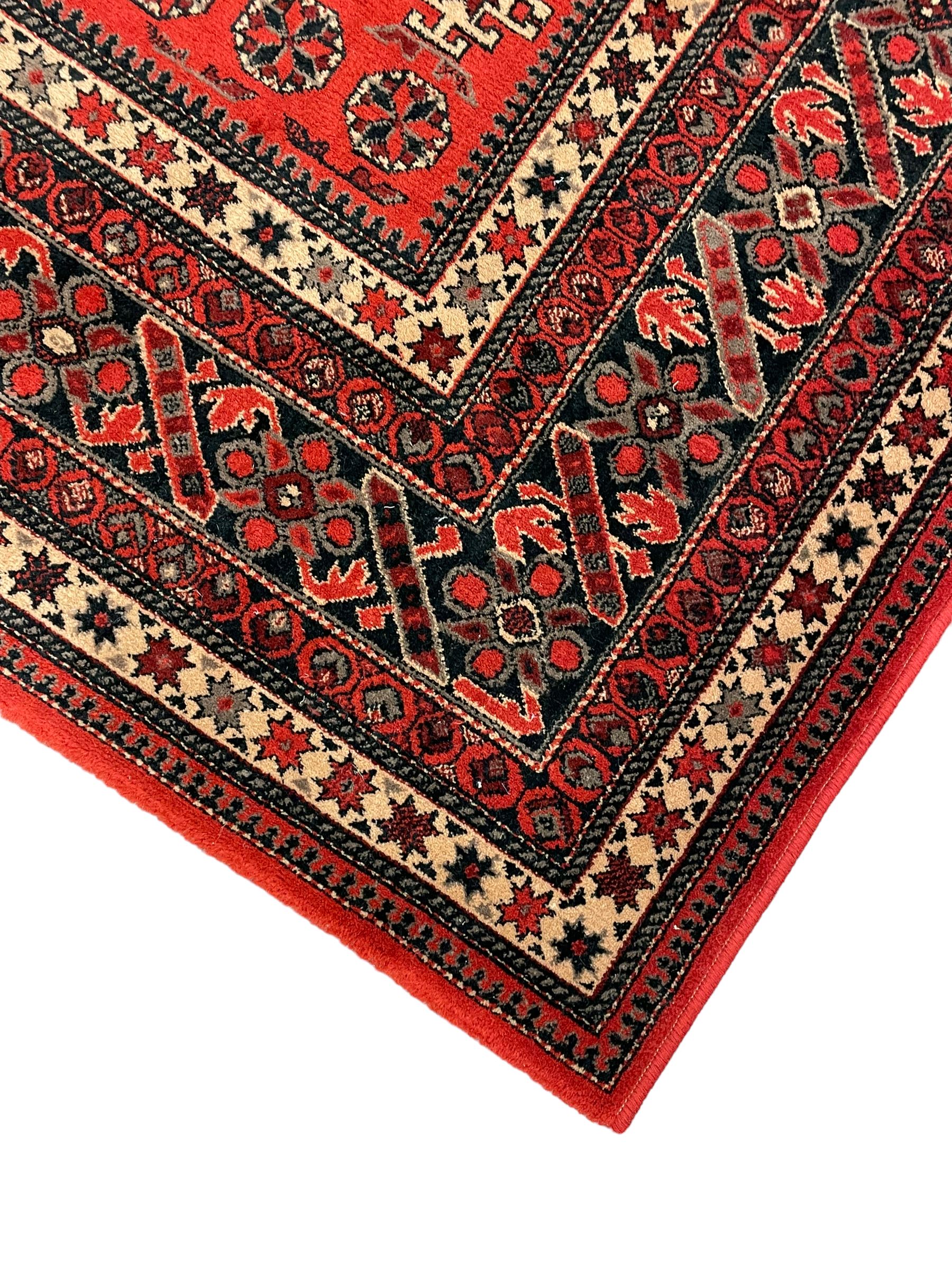 Persian design red ground rug, the field decorated with geometric